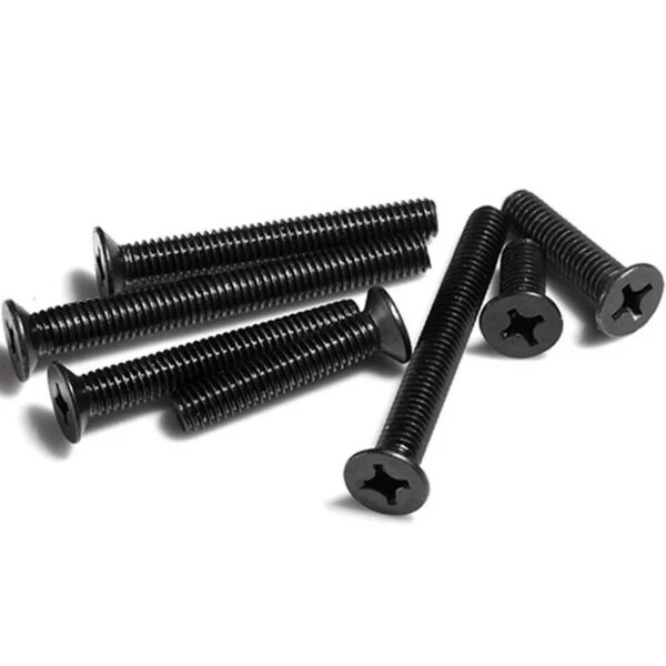 Numerous black DIN 965 stainless steel Phillips flat-head bolts are scattered on a white surface, creating a neat chaos.