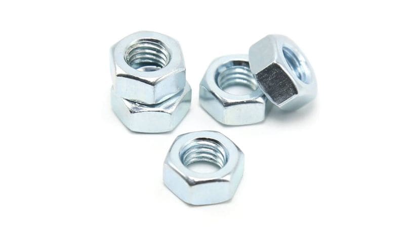 Five steel hex nuts on a white background, some stacked, others flat, display typical arrangements for assembly projects.