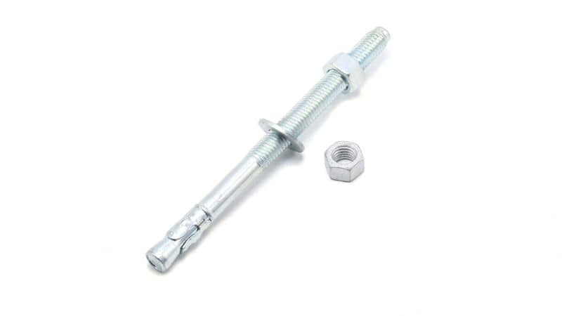 A metal wedge anchor bolt with washer and nut on white background