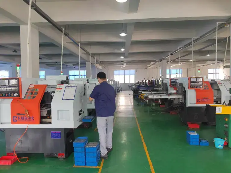 Modern manufacturing facility at Oukailuo with multiple CNC machines and workers operating in a spacious, well-lit environment.